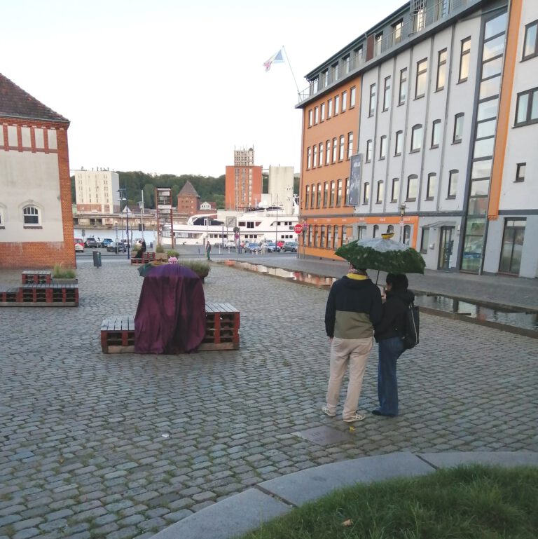 Menschen hören unter dem Regenschirm Geschichten